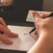 main en train d'écrire une lettre